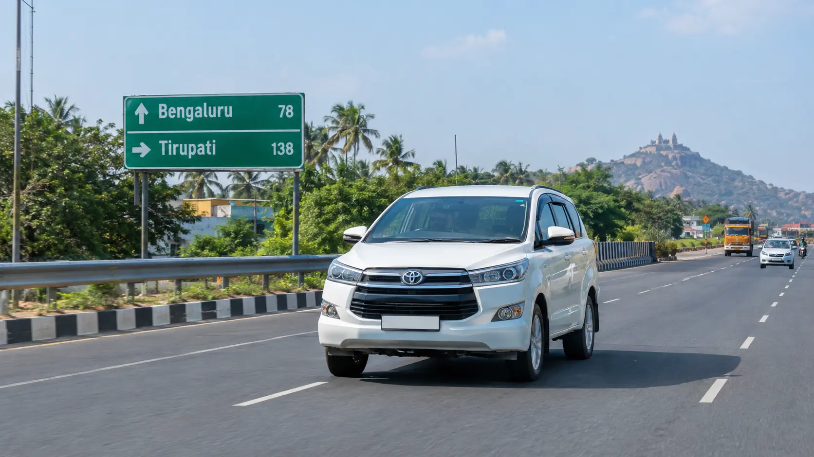 White Innova Crysta taxi on the Bangalore to Tirupati highway, with a road sign showing distances to Bengaluru and Tirupati