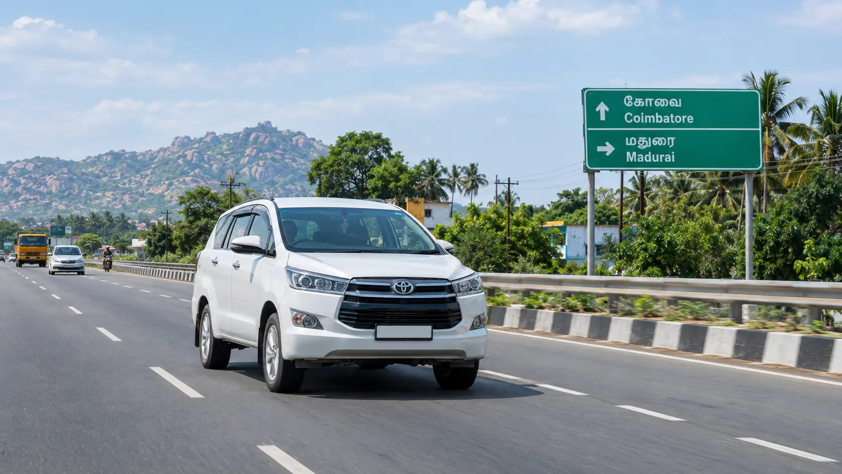 White taxi on the Coimbatore to Madurai highway, with a bilingual road sign showing Coimbatore and Madurai